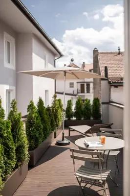 a patio with a table and an umbrella at Kuntino Suites in Merano