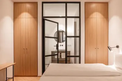 a bedroom with a bed and wooden cabinets at Kuntino Suites in Merano