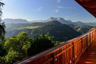 a balcony with a view of mountains and trees at Bio Kräuterhof Oberpalwitter in Barbiano
