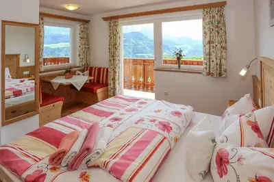 a bedroom with two beds and a window at Bio Kräuterhof Oberpalwitter in Barbiano