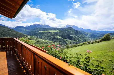 a wooden balcony with a view of mountains at Bio Kräuterhof Oberpalwitter in Barbiano