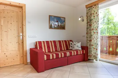 a red couch in a living room with a window at Bio Kräuterhof Oberpalwitter in Barbiano