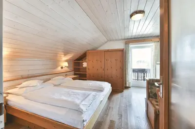 a bedroom with a bed in a wooden ceiling at Hotel Gasthof Stern in Nova Ponente