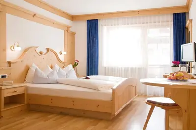 a bedroom with a large bed with a window at Garni Cristin & Dep Antina in Colfosco