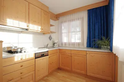 a kitchen with wooden cabinets and a window at Garni Cristin & Dep Antina in Colfosco