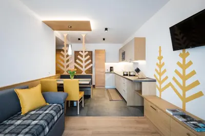 a living room and kitchen with a couch and a table at Alpinus Agriturism in San Martino in Badia