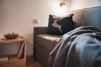 a bed with a pillow with a deer on it next to a table at Ciasa Altonn in Colfosco