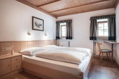 a bedroom with a large bed and a chair at Ciasa Altonn in Colfosco