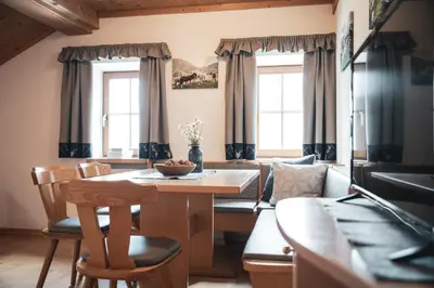 a living room with a table and chairs and a couch at Ciasa Altonn in Colfosco