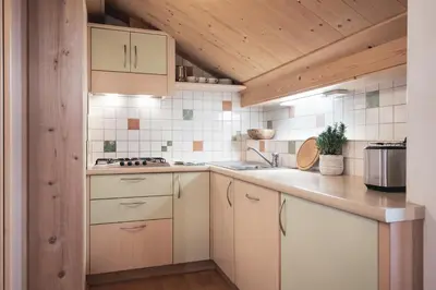 a kitchen with white cabinets and a counter top at Ciasa Altonn in Colfosco