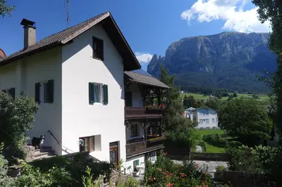 a white house with a mountain in the background at Apartments Garni Steffi in Fiè
