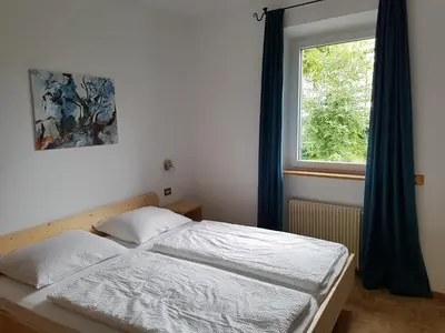 two beds in a room with a window at Apartments Garni Steffi in Fiè
