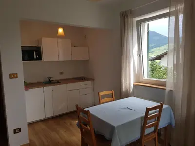 a small kitchen with a table and a window at Apartments Garni Steffi in Fiè