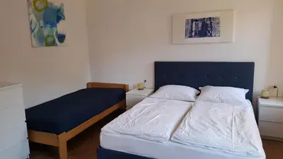 a bedroom with a bed with a blue headboard at Apartments Garni Steffi in Fiè
