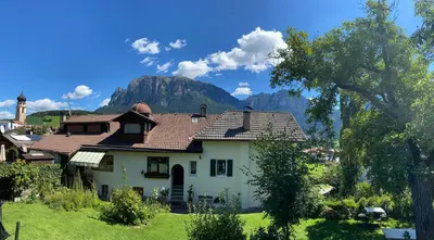 a house with a mountain in the background at Apartments Garni Steffi in Fiè