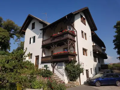 a white building with a balcony and a car at Apartments Garni Steffi in Fiè