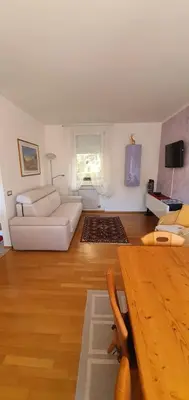 a living room with a white couch and a table at Casa Mia in Vadena
