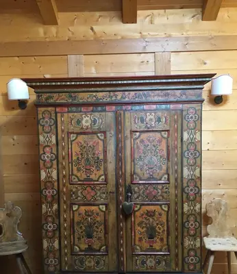a large wooden door in the corner of a room at La casa dei cuori in Santa Cristina in Val Gardena