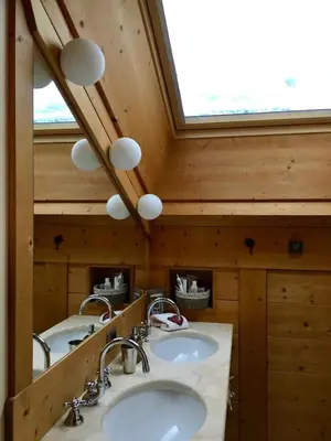 a bathroom with two sinks and a skylight at La casa dei cuori in Santa Cristina in Val Gardena