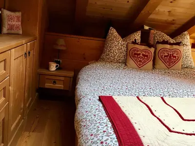 a bedroom with a bed in a log cabin at La casa dei cuori in Santa Cristina in Val Gardena