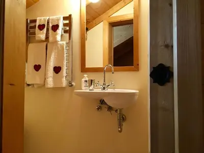 a bathroom with a sink and a mirror and towels at La casa dei cuori in Santa Cristina in Val Gardena