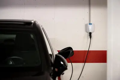 a car parked in front of a wall with a plug at Garni Hotel Peterlinhof in Caldaro