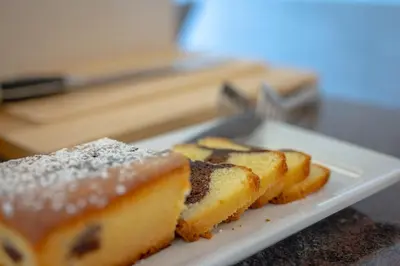 a plate of bread with powdered sugar on it at Garni Hotel Peterlinhof in Caldaro