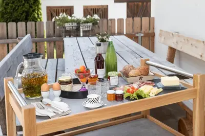 a picnic table with food and bottles of wine at Forchnerhof Panorama- Rienzschlucht in Rodengo
