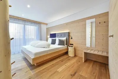 a bedroom with a bed and a wooden wall at Forchnerhof Panorama- Rienzschlucht in Rodengo