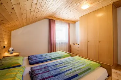 a bedroom with a bed with a wooden ceiling at Apartments Tino in La Valle
