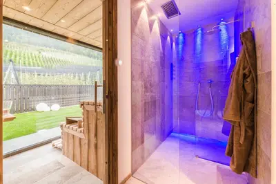 a purple bathroom with a shower and a glass door at Hotel Restaurant Kirchsteiger in Vollan