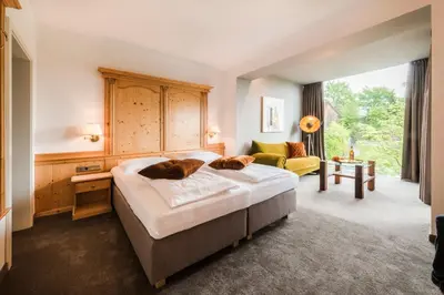 a bedroom with a large bed and a couch at Hotel Restaurant Kirchsteiger in Vollan