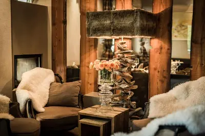 a living room with a table with a vase of flowers at Hotel Restaurant Kirchsteiger in Vollan