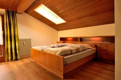 a bedroom with a large bed with a wooden ceiling at Haus Cosso in Villabassa