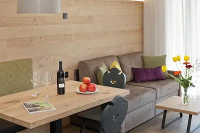 a living room with a table and a couch at Appartement-Hotel Anthea in Tirolo