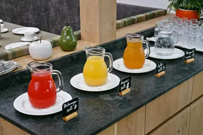 a counter with four pitchers of different types of juice at Appartement-Hotel Anthea in Tirolo