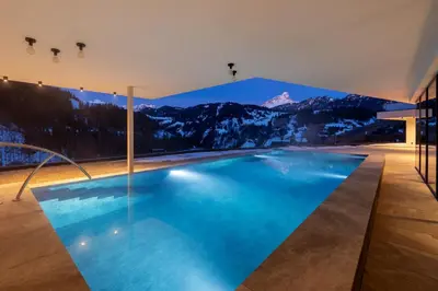 a swimming pool with a mountain mural on the wall at Hotel Alpenrose Dolomites in La Valle