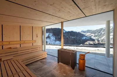 a sauna with a view of a snowy mountain at Hotel Alpenrose Dolomites in La Valle