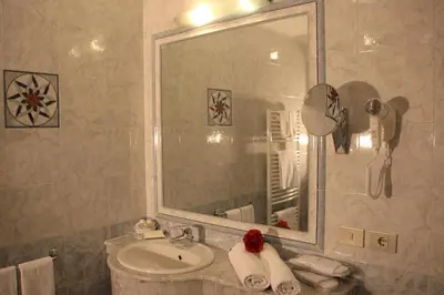 a bathroom with a sink and a mirror at Hotel Alpenrose Dolomites in La Valle