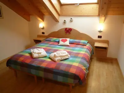 a bedroom with a bed with two towels on it at Residence Le Rose in Pozza di Fassa