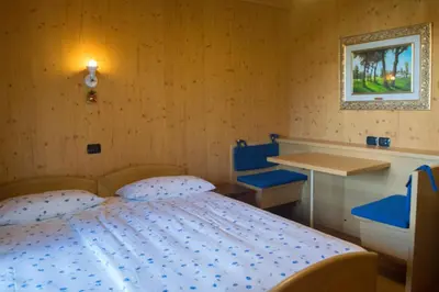 a bedroom with a bed and a desk and a table at B&B Affittacamere Larix in Rumo