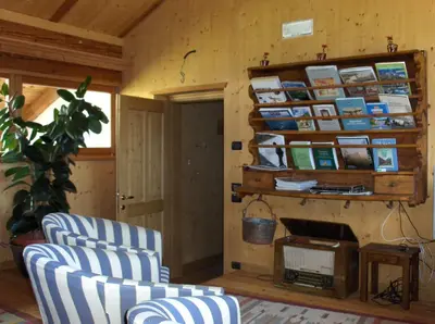 a living room with two chairs and a fireplace at B&B Affittacamere Larix in Rumo