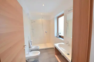 a bathroom with a toilet and a sink and a mirror at Pizzol-hof in Appiano sulla Strada del Vino