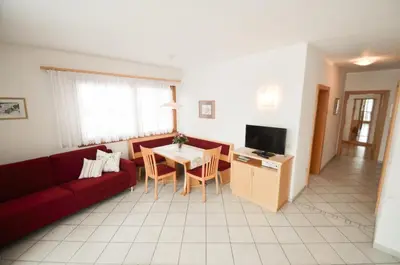 a living room with a red couch and a table at Pizzol-hof in Appiano sulla Strada del Vino