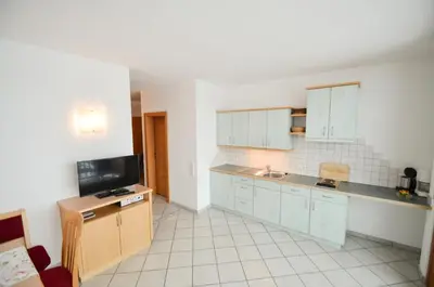 a kitchen with blue cabinets and a tv in it at Pizzol-hof in Appiano sulla Strada del Vino