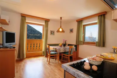 a kitchen and dining room with a table and a television at Kaserhof wandern- Alleinlage - ruhig- top Aussicht in Bressanone