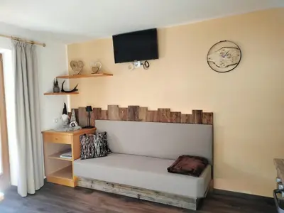 a living room with a couch and a tv on the wall at Kaserhof wandern- Alleinlage - ruhig- top Aussicht in Bressanone