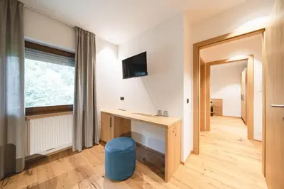 a room with a desk and a window at Hotel Lahnerhof in Vipiteno