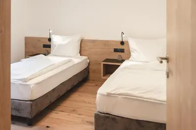 two beds sitting next to each other in a room at Hotel Lahnerhof in Vipiteno