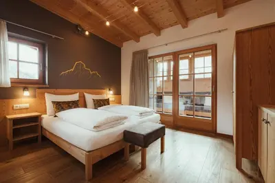 a bedroom with a large bed and a window at Refugium LaFlu Apartments in Corvara in Badia